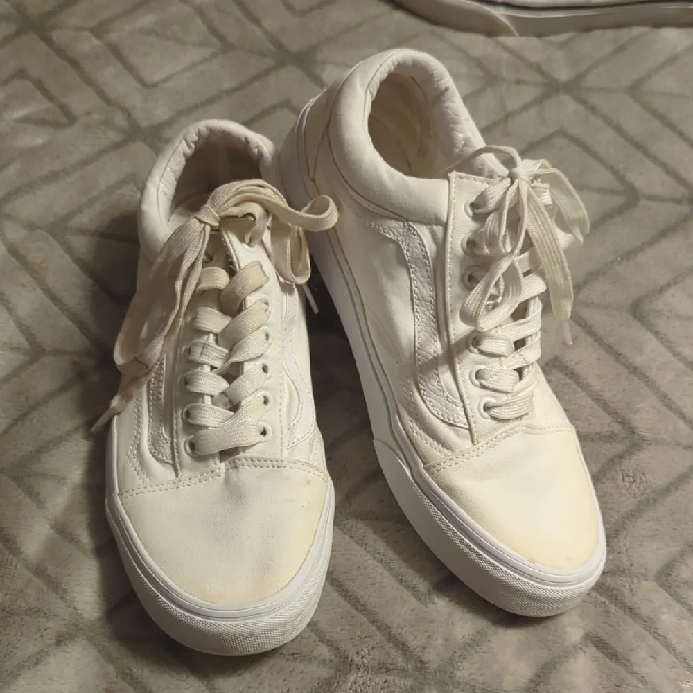 Vans Old Skool shoes in the True White or Monochrome‎ White colorway.